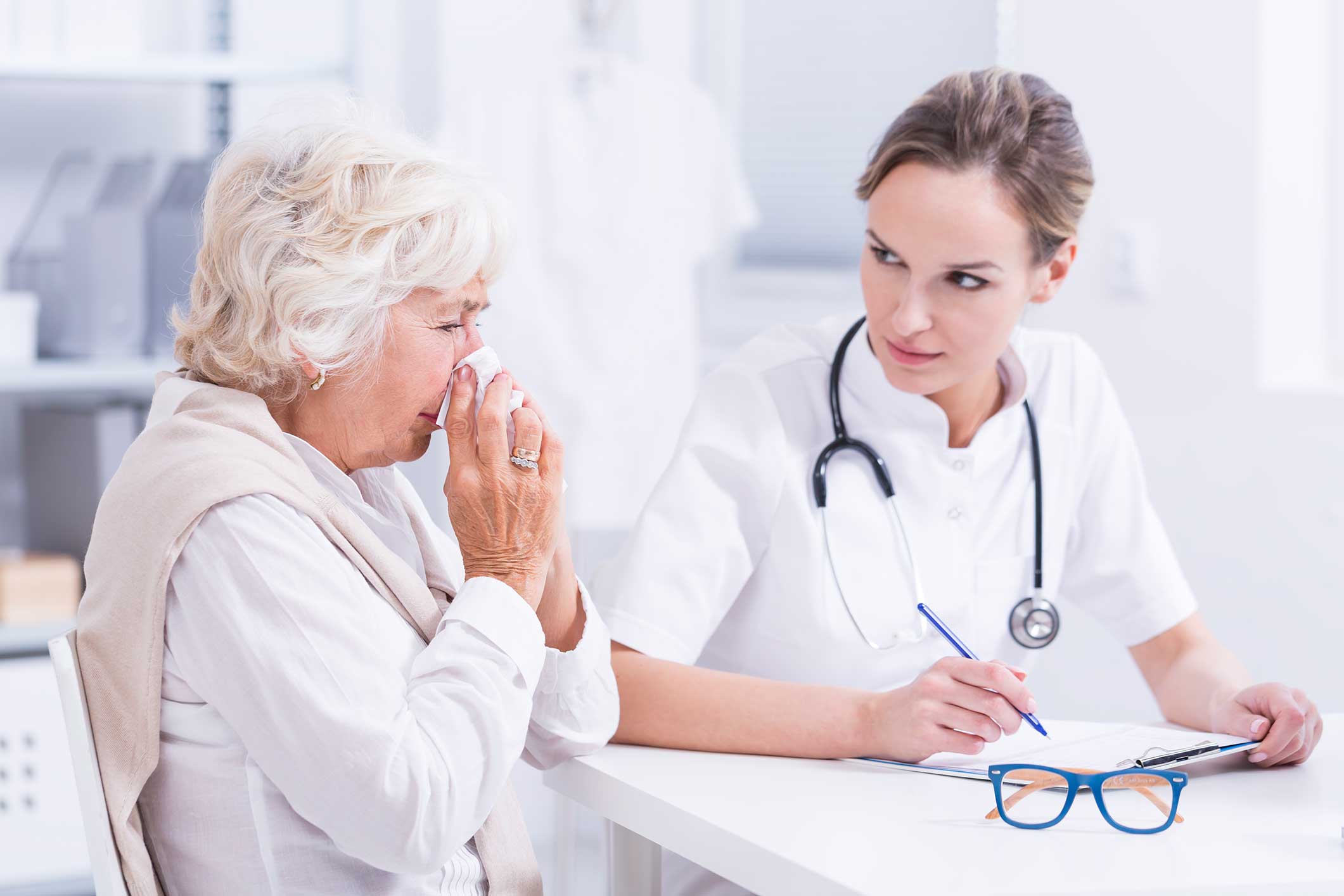 Woman blowing her nose at the doctor's office