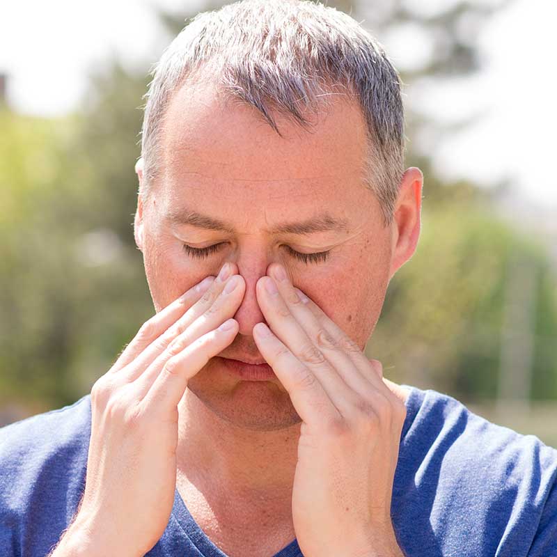 Man holding his nose and wondering if he needs a nasal polypectomy