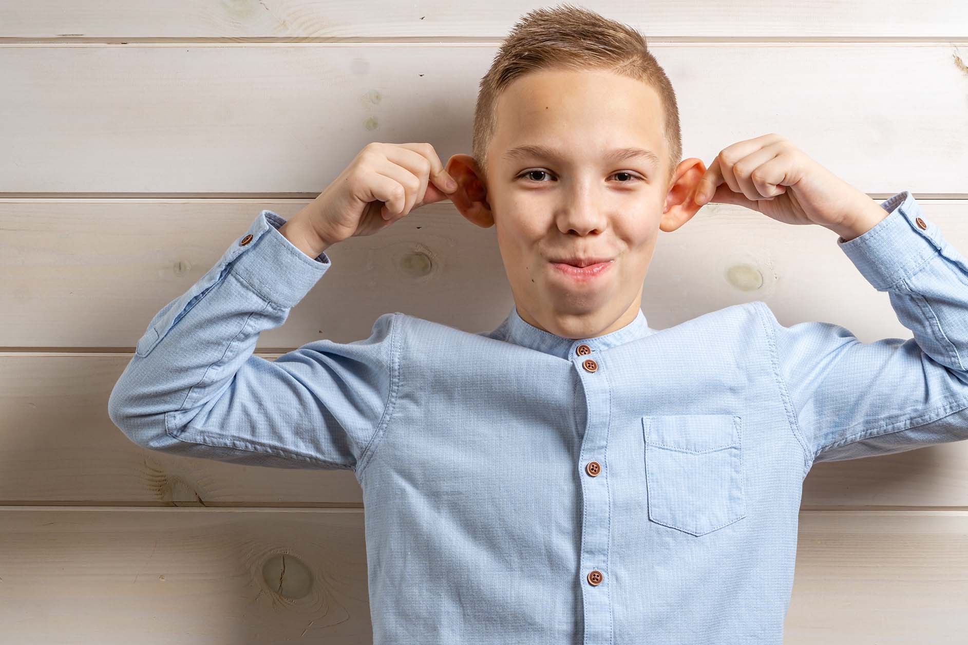 young boy pulling on his ears